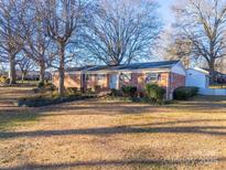 Brick ranch house with a large yard and mature trees at 1727 Hartford Dr, Gastonia, NC 28052