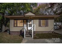 Charming one-story home with tan siding and a cozy front entrance surrounded by lush greenery at 802 E Harrison Ave, Gastonia, NC 28054