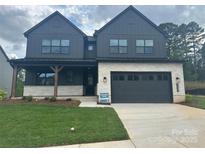 Beautiful two story home featuring a front porch, well-manicured lawn, and a two-car garage at 15009 Brownleigh Ln # 26, Huntersville, NC 28078