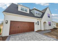 Charming home featuring a brick facade, arched entryway, and a convenient two-car garage at 817 Terra Dr, Tega Cay, SC 29708