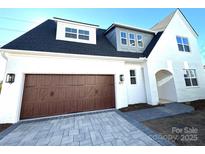 Charming two-story home featuring a dark roof, a brick finish and a two-car garage with a paved driveway at 817 Terra Dr, Tega Cay, SC 29708