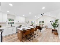 Open concept kitchen features island with seating, white shaker cabinets, and stainless steel appliances at 2443 Myrtle Ave, Gastonia, NC 28052