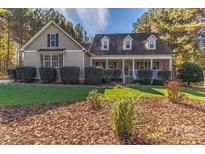 House exterior featuring a two-story home with a wraparound porch, landscaping, and stone accents at 360 Lauren Pines Dr, York, SC 29745