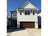 Charming two-story home with a white brick exterior and a two-car garage at 821 Terra Dr, Tega Cay, SC 29708