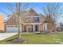 Charming two-story home with a manicured lawn, brick and stone facade and attached two car garage at 2100 Goddard Way, Waxhaw, NC 28173