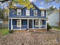 Two-story blue house with white trim, porch, and landscaping at 6934 Spring Morning Ln, Charlotte, NC 28227