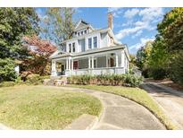 Charming two-story home featuring a welcoming front porch, beautiful landscaping, and classic architectural details at 70 Spring Nw St, Concord, NC 28025