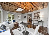 Bright game room features wood ceiling, round table, and comfortable seating at 1915 Wedgedale Dr, Charlotte, NC 28210