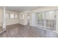 Bright living room featuring wood floors, big windows, and sliding glass doors to a private balcony at 1101 E Morehead St # 32, Charlotte, NC 28204