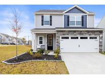 Charming two-story home featuring stone veneer, a two-car garage, and a well-maintained lawn at 159 Tanner Loop, Troutman, NC 28166