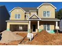 Two-story house with beige vinyl siding, a large garage, and a partially landscaped yard at 1017 Wandsworth Pl # Ken0108, Charlotte, NC 28215