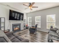 Bright living room with a ceiling fan, fireplace, and modern flooring for a comfortable atmosphere at 2512 Holly Oak Ln, Gastonia, NC 28056