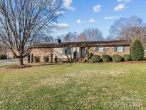 Charming single-story brick home featuring a well-maintained lawn and traditional architectural details at 105 Victoria Dr, Statesville, NC 28625