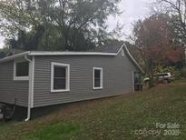 Home exterior featuring gray siding, white trim, and well-maintained landscaping at 605 N Mcfarland N St, Gastonia, NC 28054