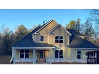 Two-story house with a light-yellow exterior, dark gray roof, and large windows at 217 Heartland Dr, Rock Hill, SC 29732