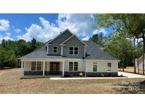New construction home with a two-tone color scheme, stone accents, and a covered front porch at 217 Heartland Dr, Rock Hill, SC 29732
