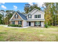 Lovely two-story house with brick and vinyl siding, black shutters, and a cozy front porch at 3018 Corinth Church Rd, Monroe, NC 28112