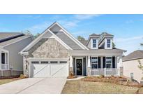 Charming home featuring stone and shingle siding, front porch and two-car garage at 3067 Trace Meadow Ct, York, SC 29745
