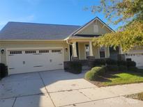 Charming single-Gathering home showcasing a well-maintained lawn, two-car garage, and inviting front porch at 129 Johnson Manor St, Mooresville, NC 28115