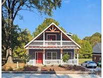 Two-story house with a gray exterior, red door, and wrap-around porch at 1703 Polk St, Monroe, NC 28110