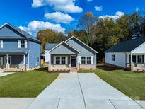 Charming gray home with inviting curb appeal, concrete driveway, and well-manicured lawn at 606 Meadow Ave, Spencer, NC 28159