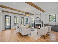 Spacious living room with wood beams, fireplace, and hardwood floors at 705 Mcalway Rd, Charlotte, NC 28211