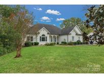 White brick ranch home with attached two-car garage and landscaped lawn at 116 Jim Parker Rd, Wesley Chapel, NC 28110