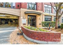 Inviting building entrance with brick accents and colorful flower beds, providing a warm welcome at 2125 Southend Dr # 349, Charlotte, NC 28203