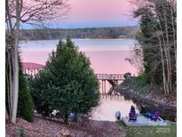 A picturesque waterfront view with a private dock and serene water, perfect for enjoying peaceful lakeside living at 9542 Riviera Dr, Sherrills Ford, NC 28673