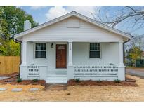 Newly renovated white house with brown door, porch, and landscaping at 119 Nat Barber Ave, Gastonia, NC 28052