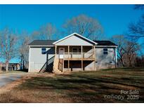 Newly constructed home with a gray exterior, front porch, and steps leading to the entrance at 201 School St, High Shoals, NC 28077