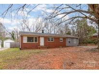 Charming single-story brick home with a white door and mature trees in the front yard at 2209 Dale Ave, Lincolnton, NC 28092