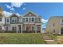 Two-story townhome with green siding, brick accents, and a landscaped lawn at 9744 Inkberry Dr, Gastonia, NC 28056