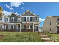 Two-story townhome with green siding, brick accents, and a landscaped lawn at 9744 Inkberry Dr, Gastonia, NC 28056