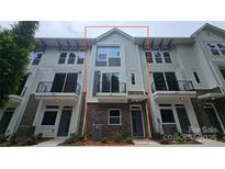 Modern townhouse with a mix of brick and siding, featuring black metal balconies, ample windows, and a welcoming entrance at 1421 Collier Walk Aly # Csw0209, Charlotte, NC 28205