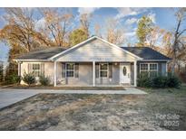 Charming single-story home featuring gray siding, a covered front porch, and a well-maintained lawn at 1681 Evans Dr, Lancaster, SC 29720