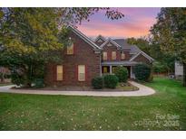 Brick two-story house with landscaped lawn and walkway at 2111 Priory Ct, Charlotte, NC 28262