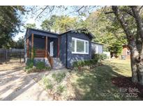 Charming home featuring a welcoming porch, landscaped yard, and stylish dark gray exterior at 3452 Airlie St, Charlotte, NC 28205