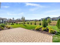 Spacious backyard with paver patio, lush landscaping, and ample green space at 6235 Scuttle Ln, Denver, NC 28037