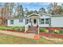 Charming single-story home with well-manicured landscaping and a welcoming front porch decorated for fall at 2164 Mission Rd, York, SC 29745