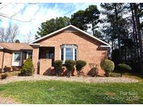 Charming brick home featuring a well-maintained lawn and manicured shrubbery at 206 Swaim Ct, Salisbury, NC 28147