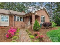 Traditional brick home with blooming azaleas, mature landscaping, and a brick walkway at 206 Swaim Ct, Salisbury, NC 28147