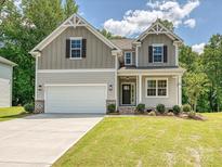 Charming two-story home featuring a two-car garage, craftsman details, and manicured front lawn at 2387 Trundle Dr # Cwo0155, Gastonia, NC 28054