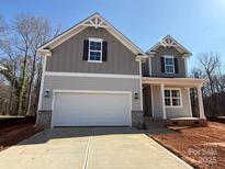 Charming two-story home with gray siding, a two-car garage, and classic architectural details at 2387 Trundle Dr # Cwo0155, Gastonia, NC 28054