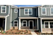 New construction townhome with gray siding, brick accents and a covered entryway at 115 Ciara Pl # B, Mooresville, NC 28117