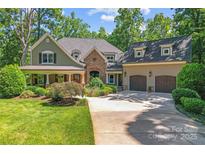 Beautiful home with a stone archway and a two-car garage with dormer windows at 20361 Enclave Oaks Ct, Cornelius, NC 28031
