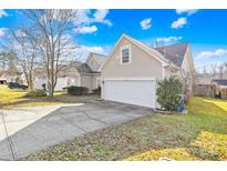 Beige house with a two-car garage and a well-maintained lawn at 136 Kristens Court Dr, Mooresville, NC 28115