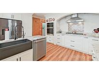 Modern kitchen featuring granite countertops, stainless steel appliances, and a farmhouse sink at 206 N Trexler Ave, Rockwell, NC 28138