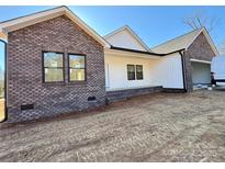 New construction shows brick and white siding with black trim and unfinished yard at 2410 Brantley Rd, Kannapolis, NC 28083