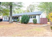 Newly renovated Ranch home with white brick exterior, black shutters, and landscaped yard at 6372 Morehead Rd, Harrisburg, NC 28075